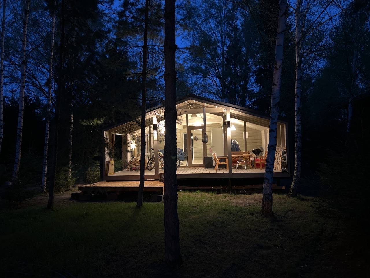 Дом с панорамными окнами и верандой в хвойном лесу