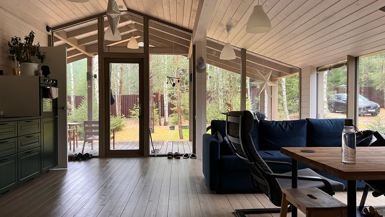 Дом с панорамными окнами и верандой в хвойном лесу