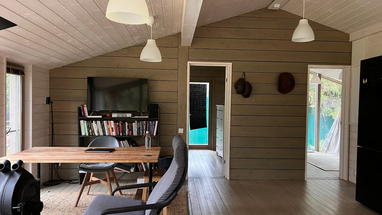 Дом с панорамными окнами и верандой в хвойном лесу